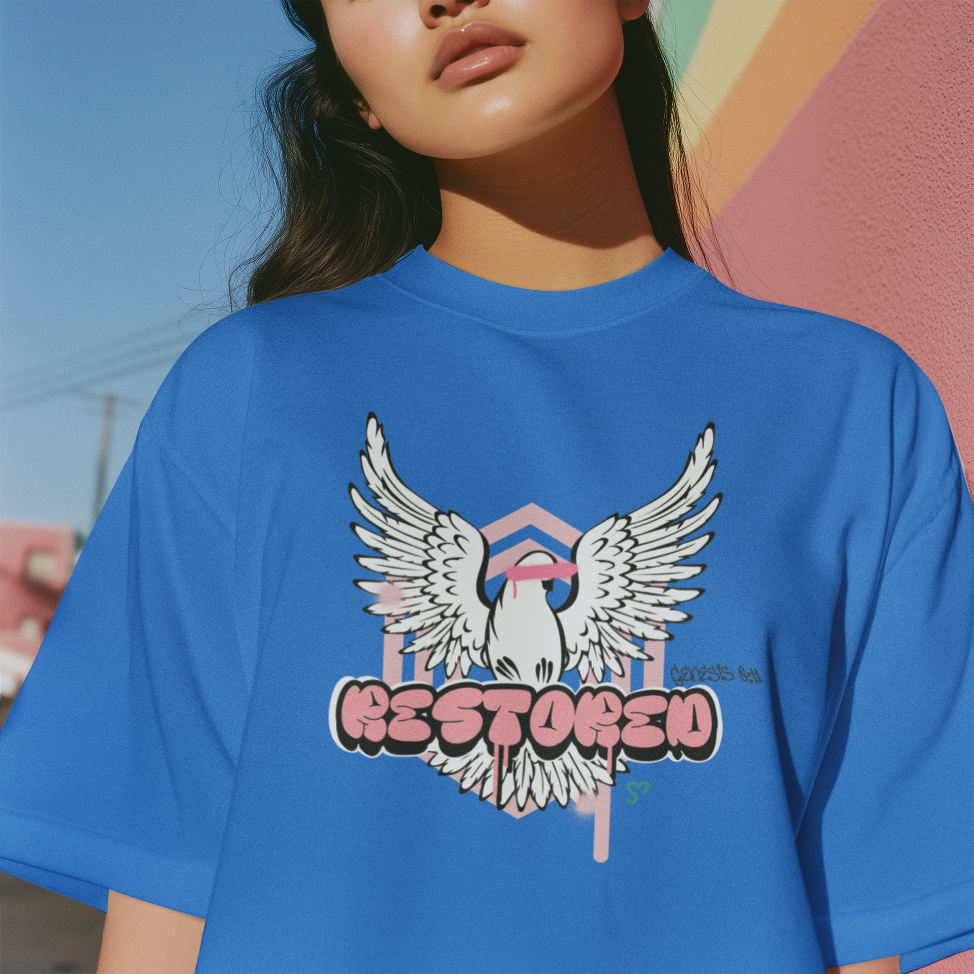 Person wearing a blue t-shirt with a graphic design of an eagle and the word 'RESTORED'.